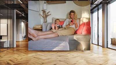 Mother and son resting on couch together Wall mural