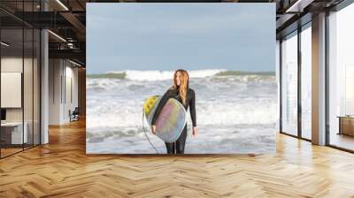 Woman with surfboard in sea Wall mural