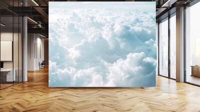 Aerial view of a vast expanse of fluffy white clouds against a pale blue sky. Wall mural