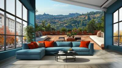 A view of green hills and a luxurious outdoor patio with two white couches, a low table and several small stools. Wall mural