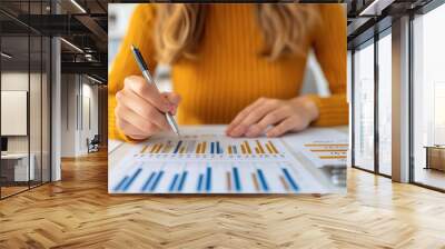 Businesswoman analyzing financial data with graphs and charts. Wall mural