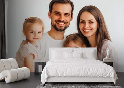 Happy family of four wearing casual outfits standing together studio background cheerful and loving Wall mural