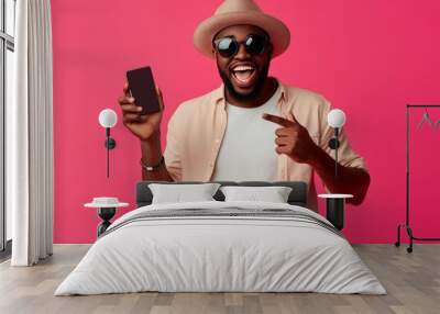 Man in casual attire excitedly presenting a popular gadget in a vibrant retail setting, solid color background, emphasizing tech trends Wall mural