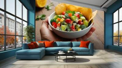 One hand holding bowl of vegetable salad, other holding chips. Healthy natural organic fresh vegetarian food vs unhealthy processed fast junk food. Lunch or snack decision Wall mural