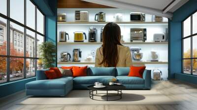 Shopper examining an assortment of luxury kitchen appliances in a modern home goods store. Wall mural