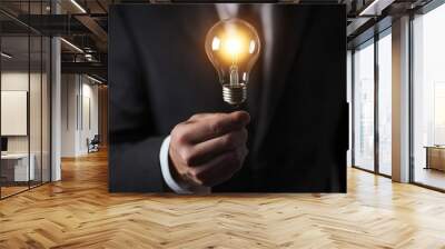 Illuminating business solutions, man in suit showcasing a bright idea with light bulb Wall mural