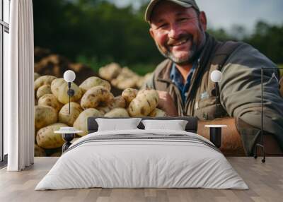 A smiling farmer proudly poses with his bountiful harvest of potatoes. Wall mural