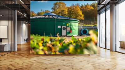 Green water tank in the middle of a lush green field Wall mural