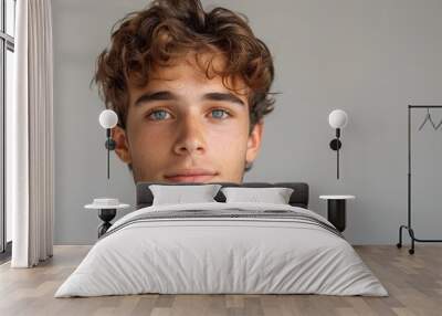 Portrait of a young man with curly hair and blue eyes Wall mural