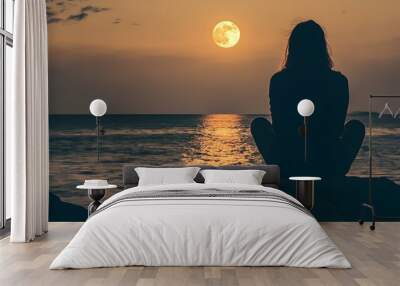 Silhouette of Woman Sitting on Rocks at Sunset With Full Moon Wall mural