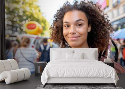 Smiling Young Woman with Curly Hair in a City Street Wall mural