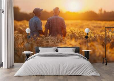 Two farmers standing in a wheat field at sunset Wall mural