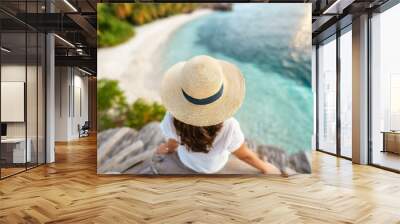 Woman in straw hat sitting on beach view from above. Summer vacation at Maldives Wall mural