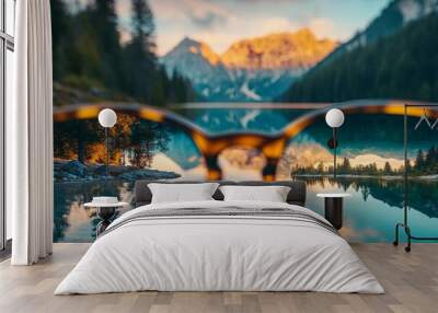 A person looking through high-end, stylish glasses at a picturesque mountain lake at sunrise. Wall mural