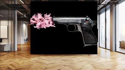 A hand gun launches a hyacinth flower isolated on black background Wall mural