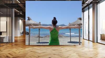 Concept of social distancing on the beach, umbrellas 2 m apart and a woman with outstretched arms measuring the social distance on the beach during the summer in the Mediterranean Sea. Wall mural