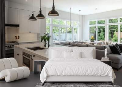 Modern white kitchen with a grey sofa and a dining table in front of large windows with green foliage views. Wall mural