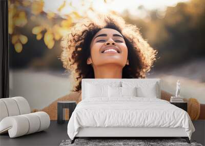 Backlit Portrait of calm happy smiling free black woman with closed eyes enjoys a beautiful moment life on the fields at sunset Wall mural