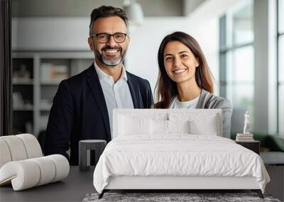 Male and female business couple posing smiling at their business office looking at the camera Wall mural