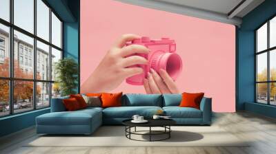 Hands holding a pink camera Wall mural