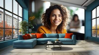 Smiling attractive confident professional woman posing at her business office with her coworkers and employees in the background Wall mural