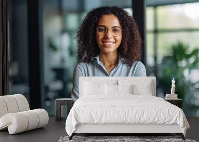 Smiling confident stylish young woman standing at the office. Young businesswoman, curly-haired lady executive business leader manager looking at camera arms crossed, generative AI Wall mural