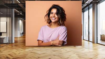 Smiling happy attractive hispanic young woman posing in studio shot Wall mural