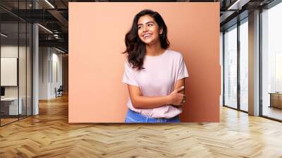 Smiling happy attractive hispanic young woman posing in studio shot Wall mural