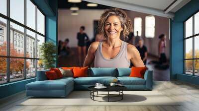 Smiling Mature woman meditating posing at a gym, pilates or yoga studio Wall mural