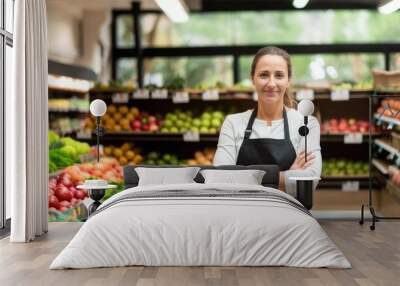 Smiling young female supermarket worker looking at the camera Wall mural