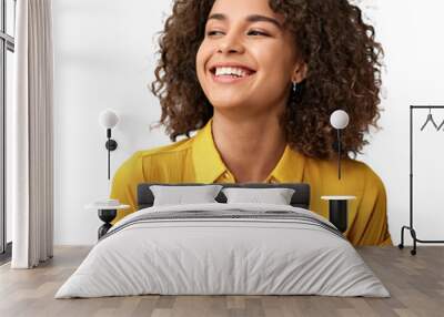 Closeup portrait of a beautiful African American woman with curly hair wearing a plain yellow shirt smiling and looking up Wall mural