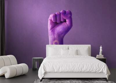 Raised purple fist of a woman for international women's day and the feminist movement. March 8 for feminism, independence, freedom, empowerment, and activism for women rights Wall mural