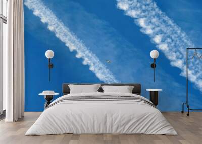 Plane crossing the sky between two chemtrails. Wall mural