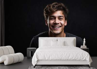 a young man is feeling very cheerful isolated on black background Wall mural