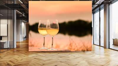 A romantic dinner in summer on a beach at sunset with two glasses of white wine Wall mural