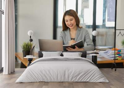 Asian business woman looking at financial documents Wall mural