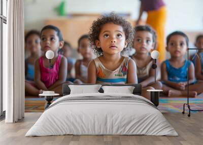 Group of small nursery school children sitting and listening to teacher on floor indoors in classroom. Wall mural