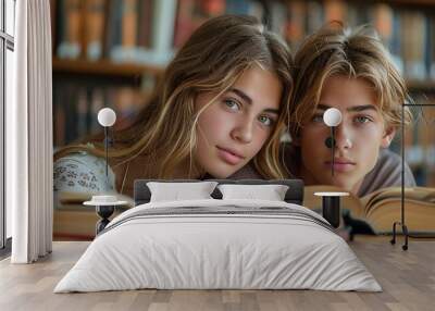 Youthful scholars, engrossed in books, library's ancient tomes behind, a meeting of eras. Wall mural