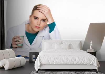 Young female student doctor sitting with a laptop on a white background Wall mural