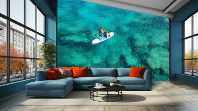 Aerial drone photo of couple practicing Stand Up Paddle or SUP in tropical exotic emerald and sapphire island sea Wall mural