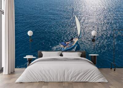 Aerial drone photo of sail boat cruising in the deep blue Aegean sea, Cyclades, Greece Wall mural