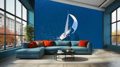 Aerial drone top down photo of beautiful sailing boat cruising in deep blue Atlantic open ocean sea Wall mural