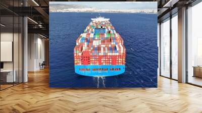 Aerial drone top down photo of huge container ship full of colourful containers cruising deep blue open ocean sea Wall mural