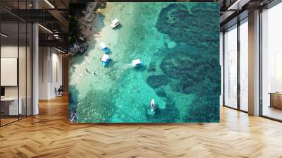 Aerial photo of iconic white cliff tropical bay forming a blue lagoon with deep turquoise clear ocean and docked small boats enjoying this unique paradise Wall mural