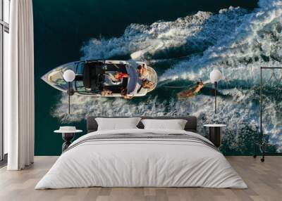 Aerial photo of woman practising waterski in Mediterranean bay with emerald sea at sunset Wall mural