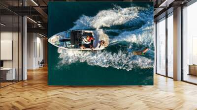 Aerial photo of woman practising waterski in Mediterranean bay with emerald sea at sunset Wall mural