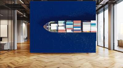 Aerial top down ultra wide photo of Container cargo Ship carrying load in truck-size colourful containers in deep blue open ocean sea  Wall mural