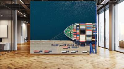 Aerial top down ultra wide photo of industrial container ship loading  - unloading colourful truck size containers with cranes in logistics terminal port Wall mural