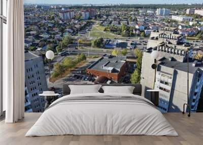 Minsk, Belarus - 27.10.2024: Dense building of a modern large Belarusian city. Neighborhood of one-storey huts, cottages and multi-storey residential buildings. View of the city of Minsk from a height Wall mural