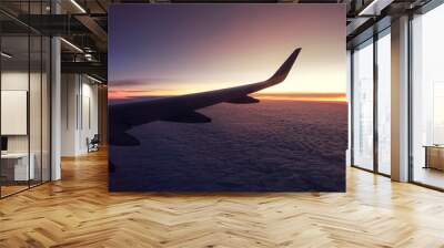 Sunset on cloudy sky as seen from a window plane above fluffy clouds Wall mural